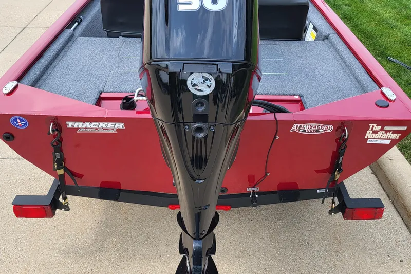 Slide: The Image of 2024 Tracker Pro 170 boat with outboard motor, red hull, and trailer. - 2