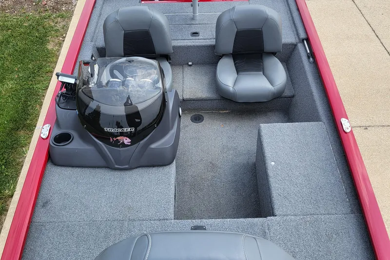 Slide: The Image of 2024 Tracker Pro 170 boat interior with gray seating and red trim. - 3