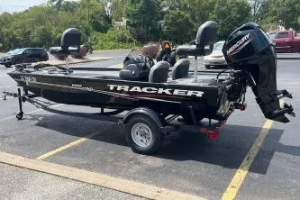 Slide: The Image of 2024 Tracker Pro 170 boat on trailer by a lake. - 2