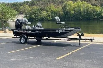 Slide: The Image of 2024 Tracker Pro 170 boat interior with gray seating by a lake. - 4