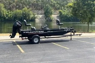 Slide: The Image of 2024 Tracker Pro 170 boat with 50 HP motor, parked near a scenic river. - 5