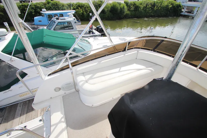 Slide: The Image of 2000 Silverton 37 Convertible boat interior with seating, docked near other boats. - 12