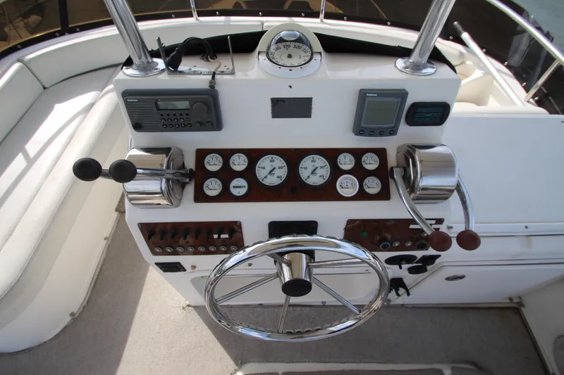 Slide: The Image of Control panel of a 2000 Silverton 37 Convertible boat with steering wheel and gauges. - 17
