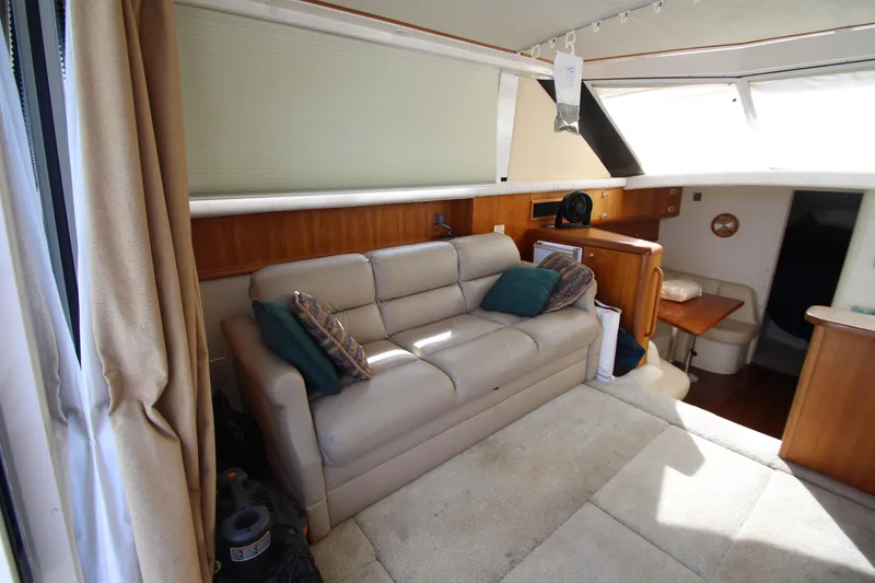 Slide: The Image of Interior of 2000 Silverton 37 Convertible yacht with beige sofa and wooden accents. - 20