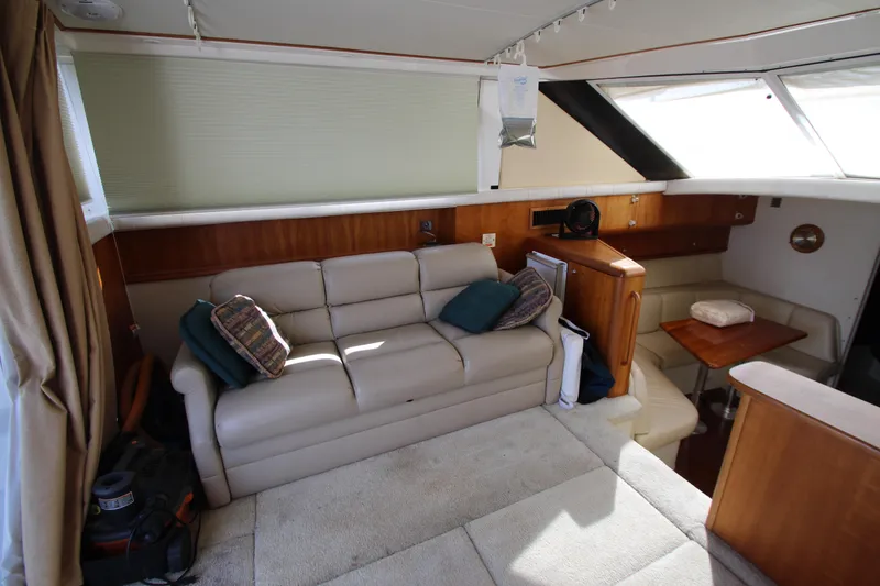 Slide: The Image of Interior of 2000 Silverton 37 Convertible yacht with beige sofa and wooden accents. - 21