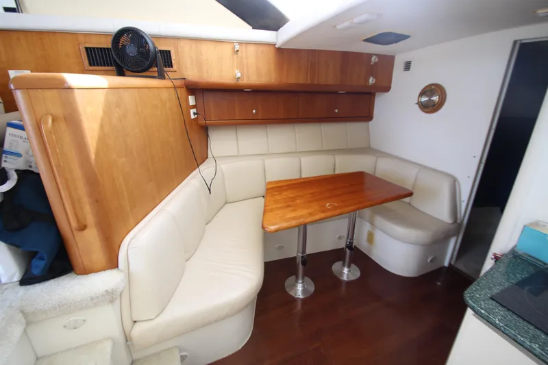 Slide: The Image of Interior of 2000 Silverton 37 Convertible yacht with cozy dining area and wooden table. - 22