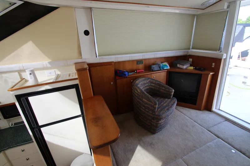 Slide: The Image of Interior of 2000 Silverton 37 Convertible yacht with cozy seating and entertainment area. - 24