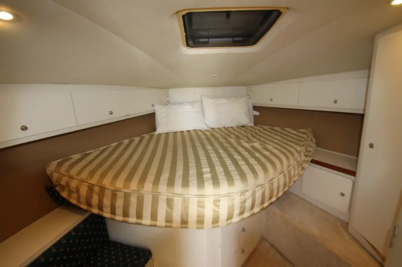 Slide: The Image of Cozy cabin interior of 2000 Silverton 37 Convertible yacht with striped bedding. - 28