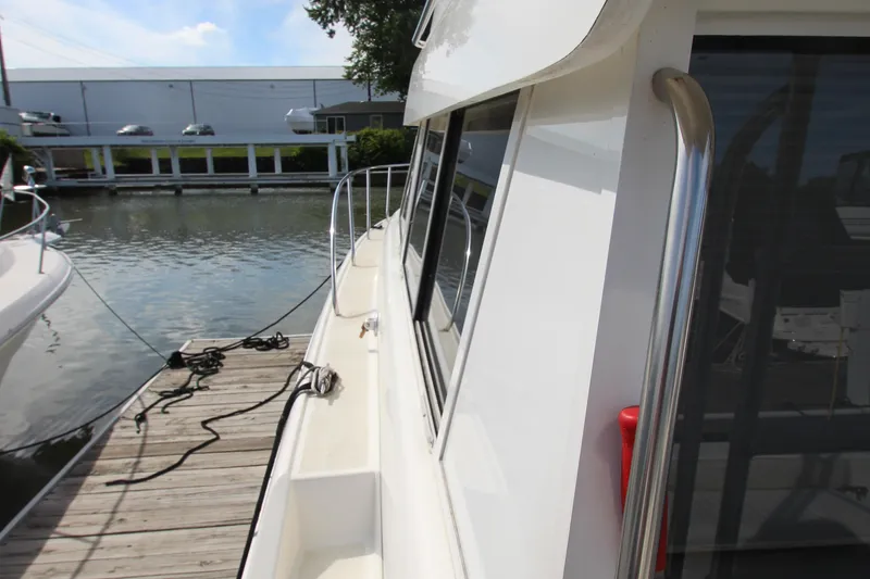 Slide: The Image of 2000 Silverton 37 Convertible yacht docked at marina, side view with railing. - 5