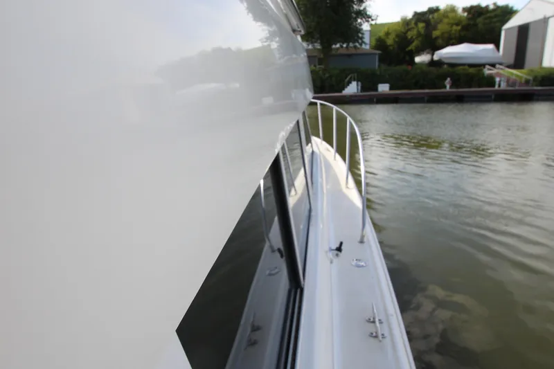 Slide: The Image of Side view of a 2000 Silverton 37 Convertible boat docked by the water. - 8