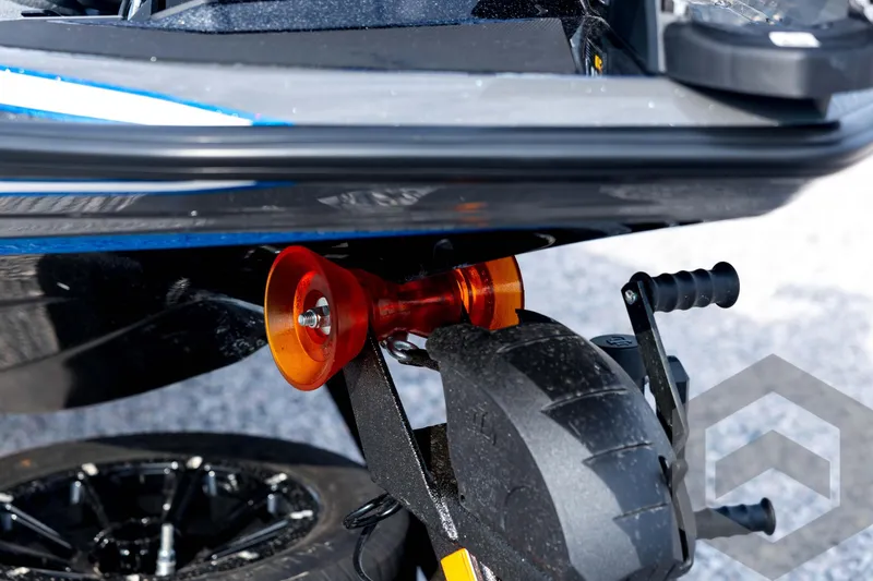 Slide: The Image of 2026 Skeeter FXR21 FLEX boat trailer detail with orange roller and black wheel. - 11