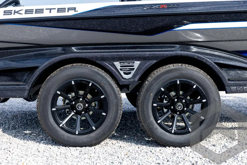 Slide: The Image of 2026 Skeeter FXR21 FLEX trailer with black alloy wheels on gravel. - 15