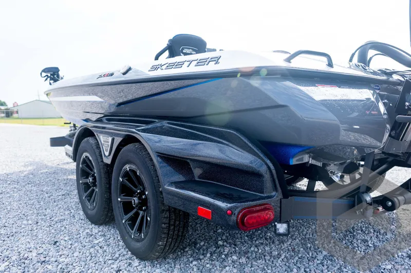 Slide: The Image of 2026 Skeeter FXR21 FLEX boat on a trailer, parked on gravel. - 30