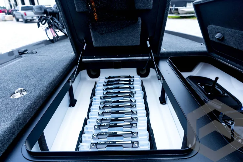 Slide: The Image of Open storage compartment in 2026 Skeeter FXR21 FLEX boat, showcasing organized tackle boxes. - 52