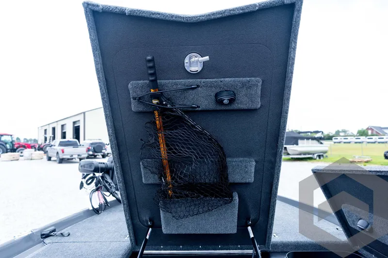 Slide: The Image of 2026 Skeeter FXR21 FLEX boat storage compartment with fishing net and equipment. - 53