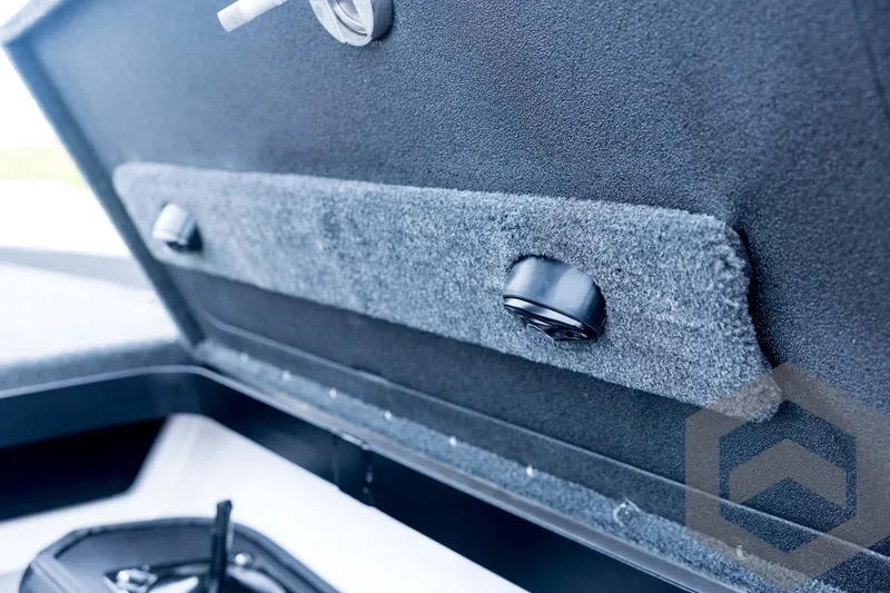 Slide: The Image of Interior view of 2026 Skeeter FXR21 FLEX boat compartment with carpeted panel and latch. - 55