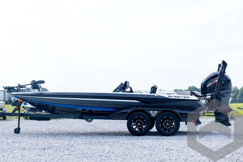 Slide: The Image of 2026 Skeeter FXR21 FLEX boat on trailer, side view, outdoors on gravel. - 8