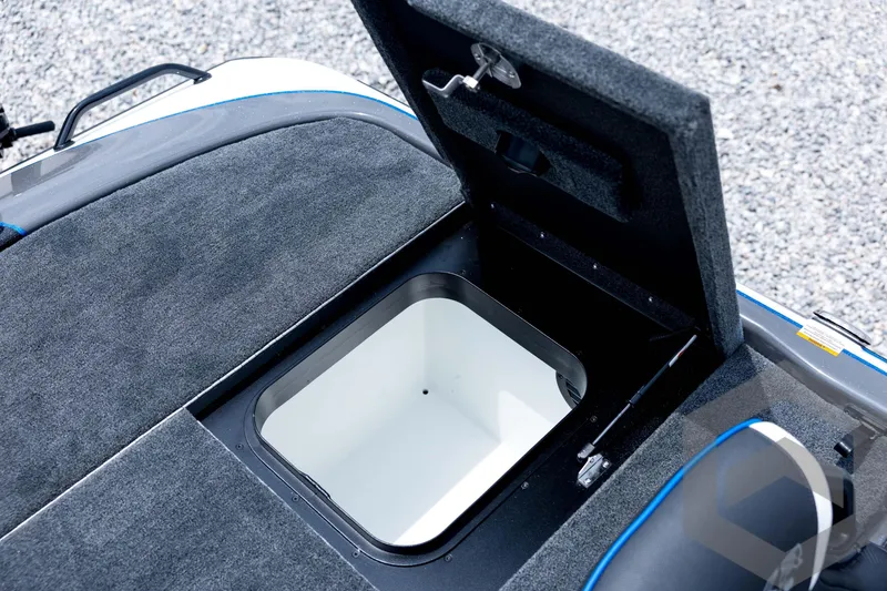 Slide: The Image of Open storage compartment on 2026 Skeeter FXR21 FLEX boat, featuring carpeted interior. - 81