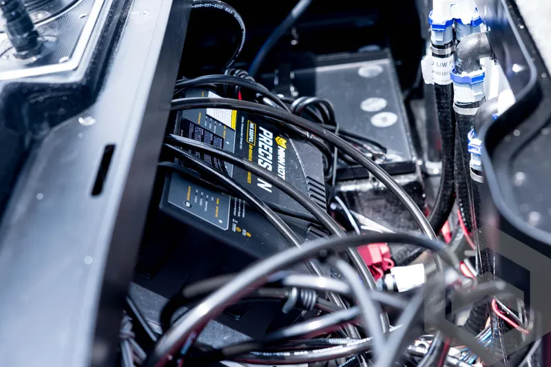 Slide: The Image of 2026 Skeeter FXR21 FLEX boat wiring and battery compartment with Minn Kota charger. - 90