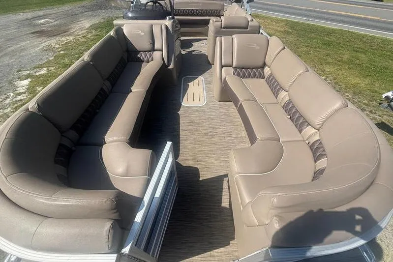 Slide: The Image of 2020 Bennington 25 RSB pontoon boat with spacious beige seating and modern design. - 11
