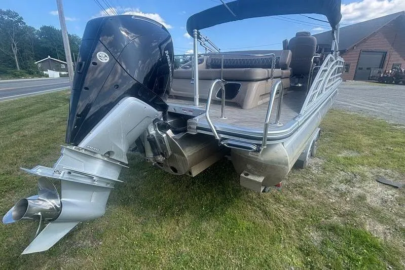 Slide: The Image of 2020 Bennington 25 RSB pontoon boat with powerful outboard motor on grassy area. - 4