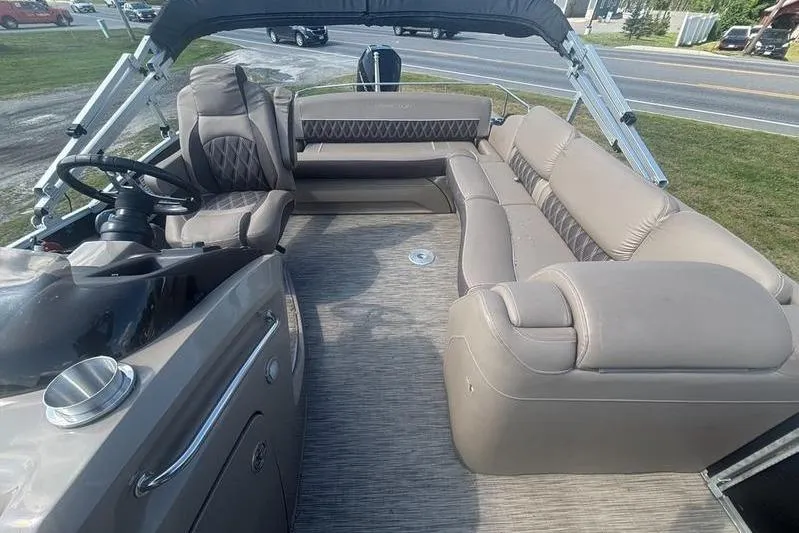 Slide: The Image of 2020 Bennington 25 RSB pontoon boat interior with plush seating and steering console. - 7