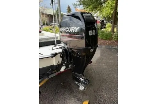 Slide: The Image of 2017 Mako Pro Skiff 17 CC with Mercury 60 outboard motor in a driveway setting. - 2