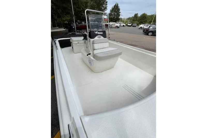 Slide: The Image of 2017 Mako Pro Skiff 17 CC boat with center console and seating, parked outdoors. - 3
