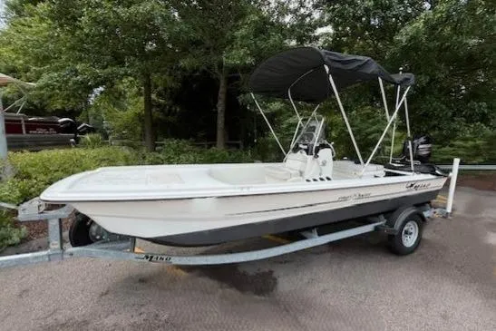 Slide: The Image of 2017 Mako Pro Skiff 17 CC boat on trailer, parked outdoors with trees in background. - 5