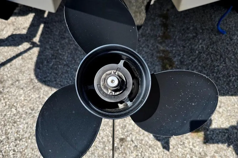 Slide: The Image of Close-up of a 2019 Bayliner VR5 Bowrider I/O boat propeller on pavement. - 16