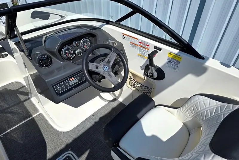 Slide: The Image of 2019 Bayliner VR5 Bowrider I/O dashboard and steering wheel, featuring modern controls and seating. - 2