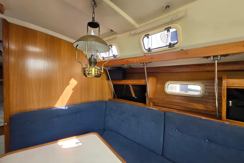 Slide: The Image of Interior of a 1994 Catalina 34 sailboat with blue seating and wooden accents. - 10
