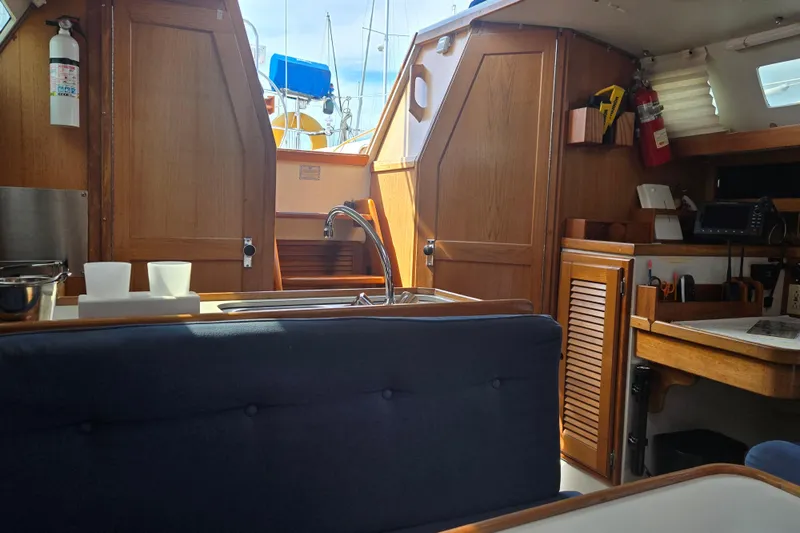 Slide: The Image of Interior of a 1994 Catalina 34 sailboat with wooden cabinetry and seating area. - 11
