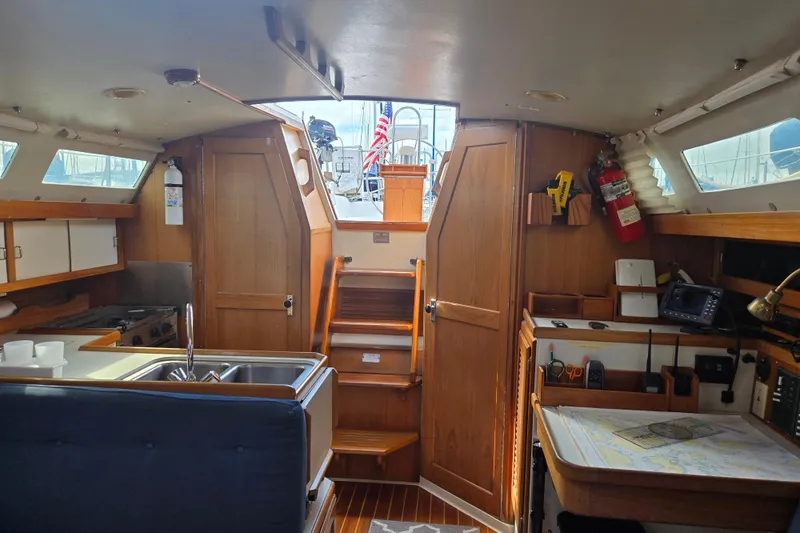 Slide: The Image of Interior of a 1994 Catalina 34 sailboat with wooden cabinetry and navigation equipment. - 12