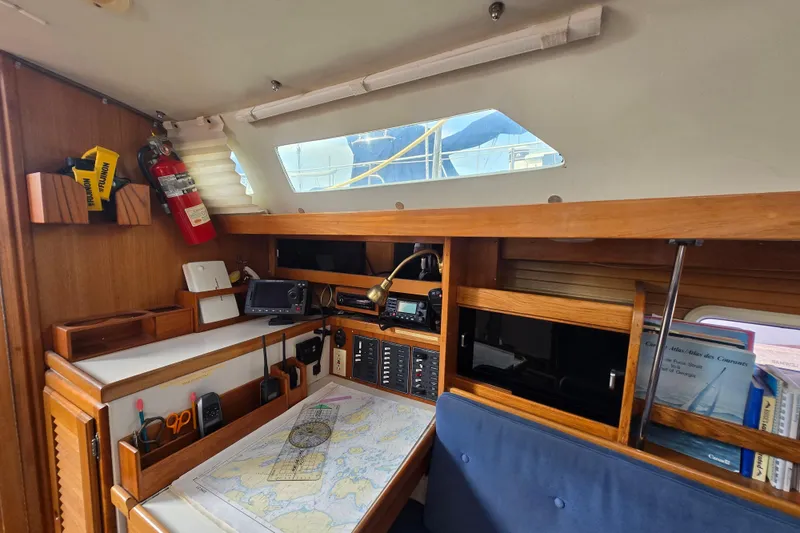 Slide: The Image of Navigation station inside a 1994 Catalina 34 sailboat with charts and equipment. - 13