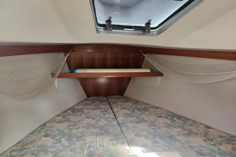 Slide: The Image of Interior cabin of a 1994 Catalina 34 sailboat with floral-patterned bedding. - 14
