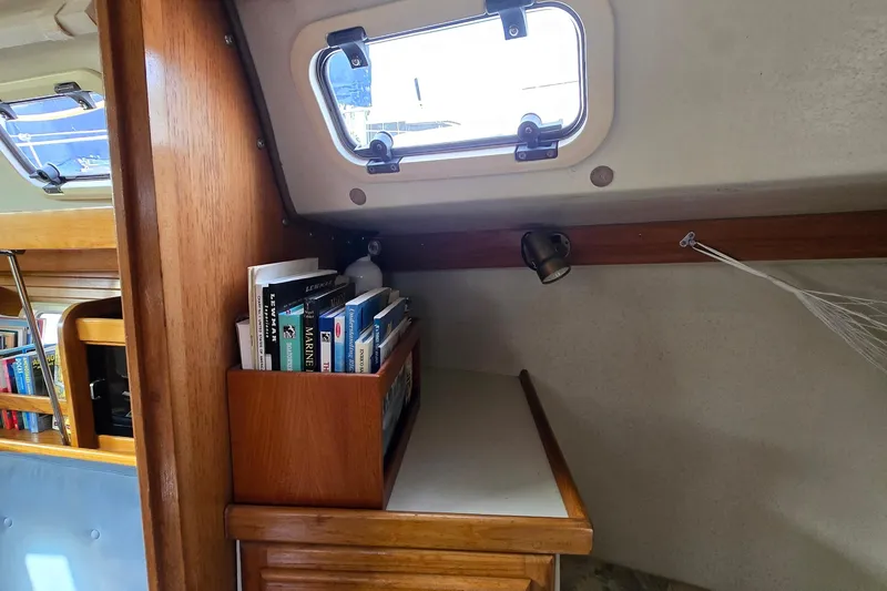 Slide: The Image of Interior of a 1994 Catalina 34 sailboat with bookshelf and porthole window. - 16
