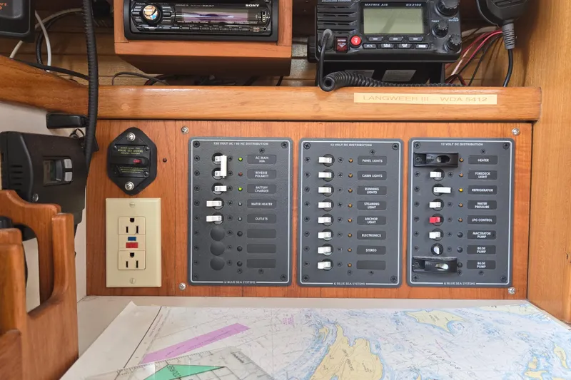 Slide: The Image of Electrical control panel on a 1994 Catalina 34 sailboat with navigation charts. - 17