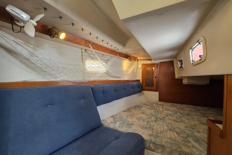 Slide: The Image of Cozy interior of 1994 Catalina 34 sailboat with blue seating and netting. - 18