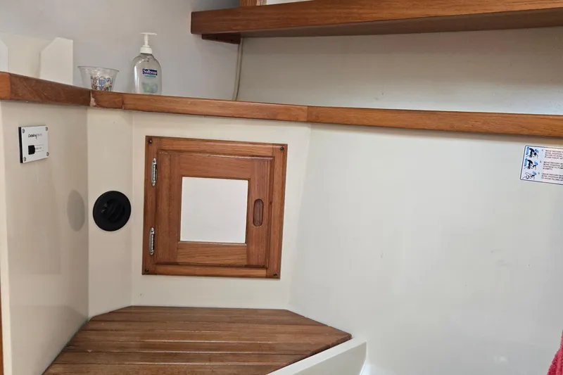 Slide: The Image of Interior of a 1994 Catalina 34 sailboat with wooden cabinetry and shelving. - 19