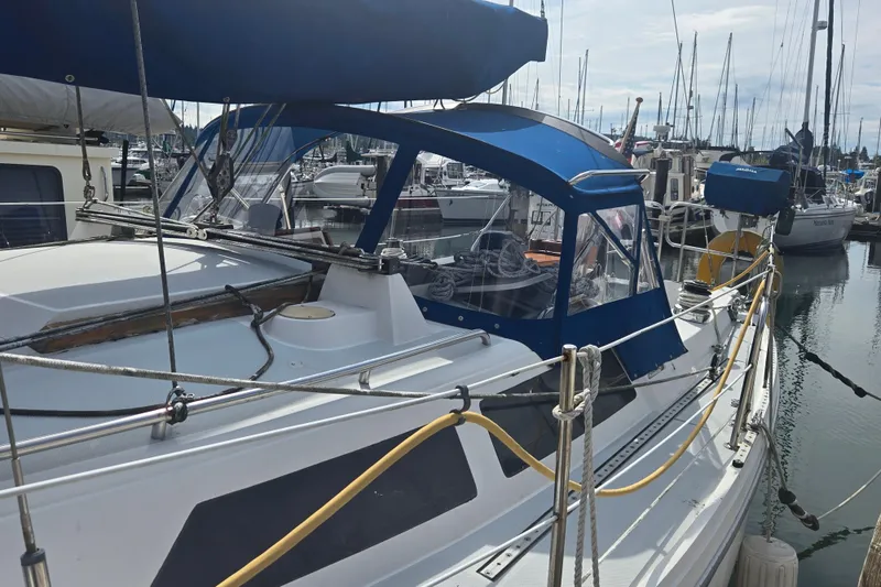 Slide: The Image of 1994 Catalina 34 sailboat docked in marina, featuring blue canopy and rigging. - 2
