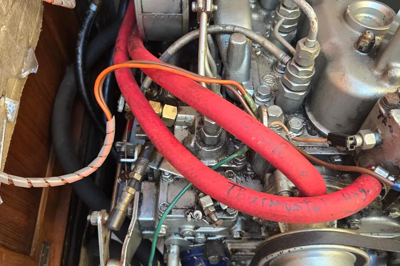 Slide: The Image of Engine components of a 1994 Catalina 34 sailboat, featuring red and orange cables. - 22