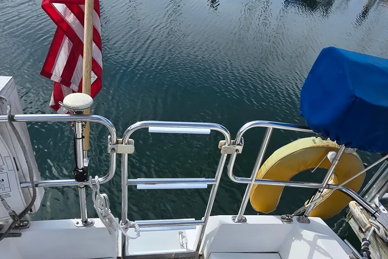 Slide: The Image of 1994 Catalina 34 sailboat stern with American flag and life preserver. - 4