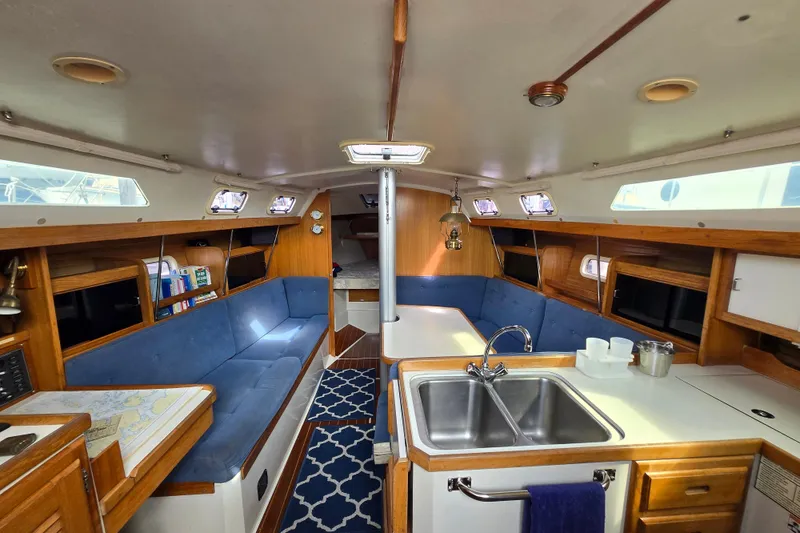 Slide: The Image of Interior of a 1994 Catalina 34 sailboat with cozy seating and kitchen area. - 6