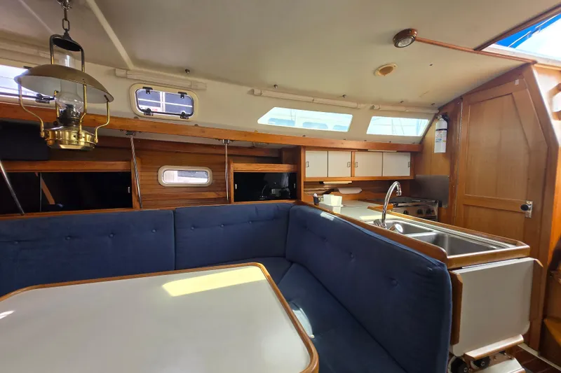 Slide: The Image of Interior of a 1994 Catalina 34 sailboat with cozy seating and kitchen area. - 8
