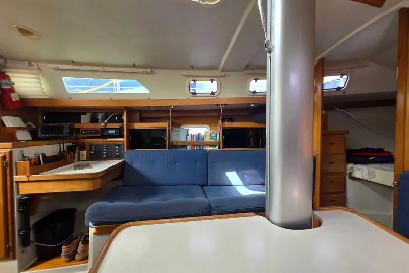 Slide: The Image of Interior of a 1994 Catalina 34 sailboat with blue seating and wooden cabinetry. - 9