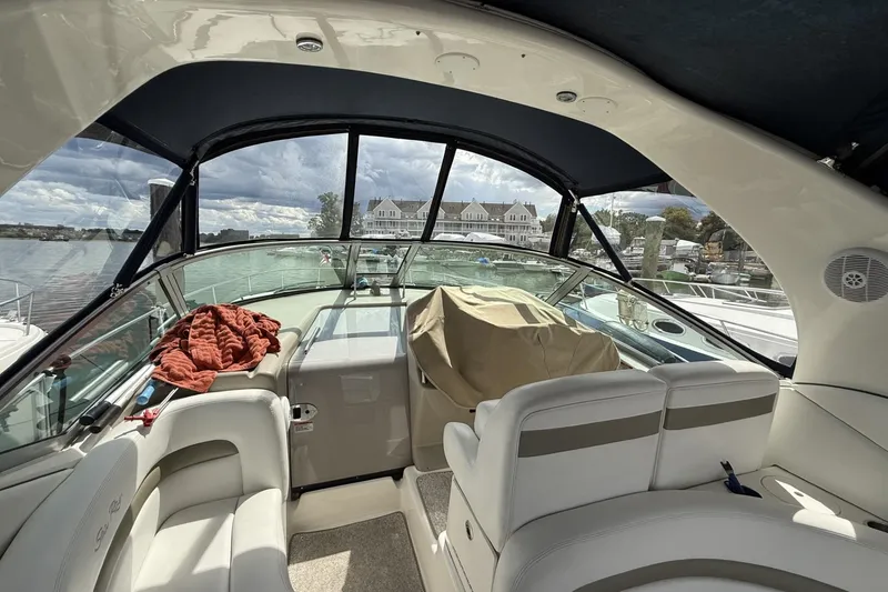 Slide: The Image of 2007 Sea Ray 320 Sundancer interior with seating, docked at marina under cloudy sky. - 10