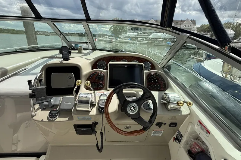 Slide: The Image of 2007 Sea Ray 320 Sundancer helm with steering wheel, controls, and navigation equipment. - 13