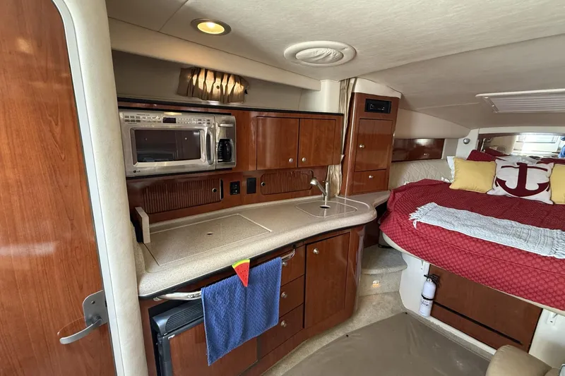 Slide: The Image of 2007 Sea Ray 320 Sundancer interior with kitchenette and cozy sleeping area. - 16