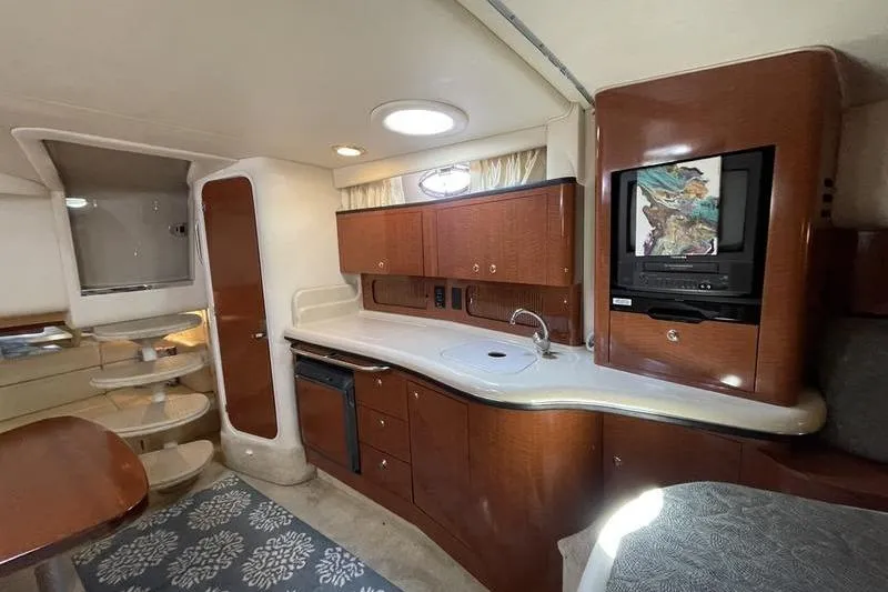 Slide: The Image of Interior of 2003 Sea Ray 320 Sundancer yacht with kitchenette and wooden cabinetry. - 12